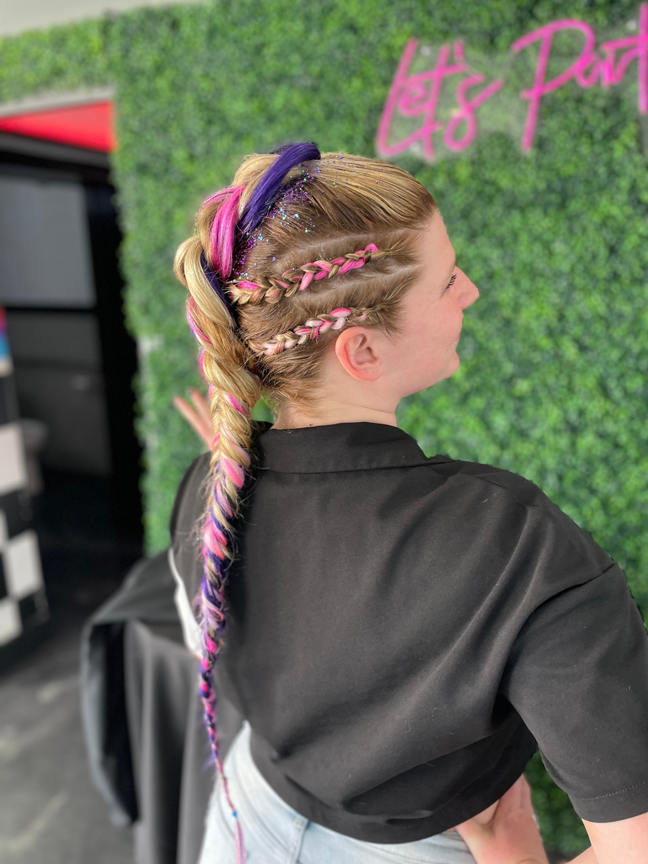 a person with purple and pink rave french braids in their hair